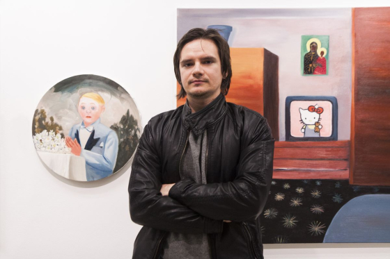 Michał Gątarek, laureat II Nagrody „Bielskiej Jesieni 2015”, w tle nagrodzone prace artysty pt.: „Chłopiec z dobrego domu” i „Po