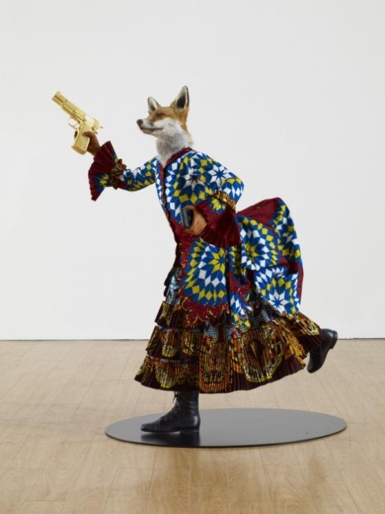 YINKA SHONIBARE, MBE; Revolution Kid (fox girl), 2012; mannequin, Dutch wax printed cotton, fibreglass, leather, taxidermy fox head, steel base plate, BlackBerry and 24 carat gold gilded gun 44 x 36 x 30 inches © The Artist / Courtesy James Cohan Gallery, New York/Shanghai