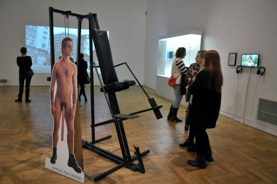Na pierwszym planie: Zbigniew Libera, "Universal Penis Expander", 1995, stojak reklamowy, plakat, maszyna, depozyt w Muzeum Szuk